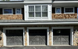 Modern outdoor living space with taupe exterior siding painted by CYR Painting Services featuring cedar timber frame porch roof, black window trim, and stone pillars on stone patio - metal exterior