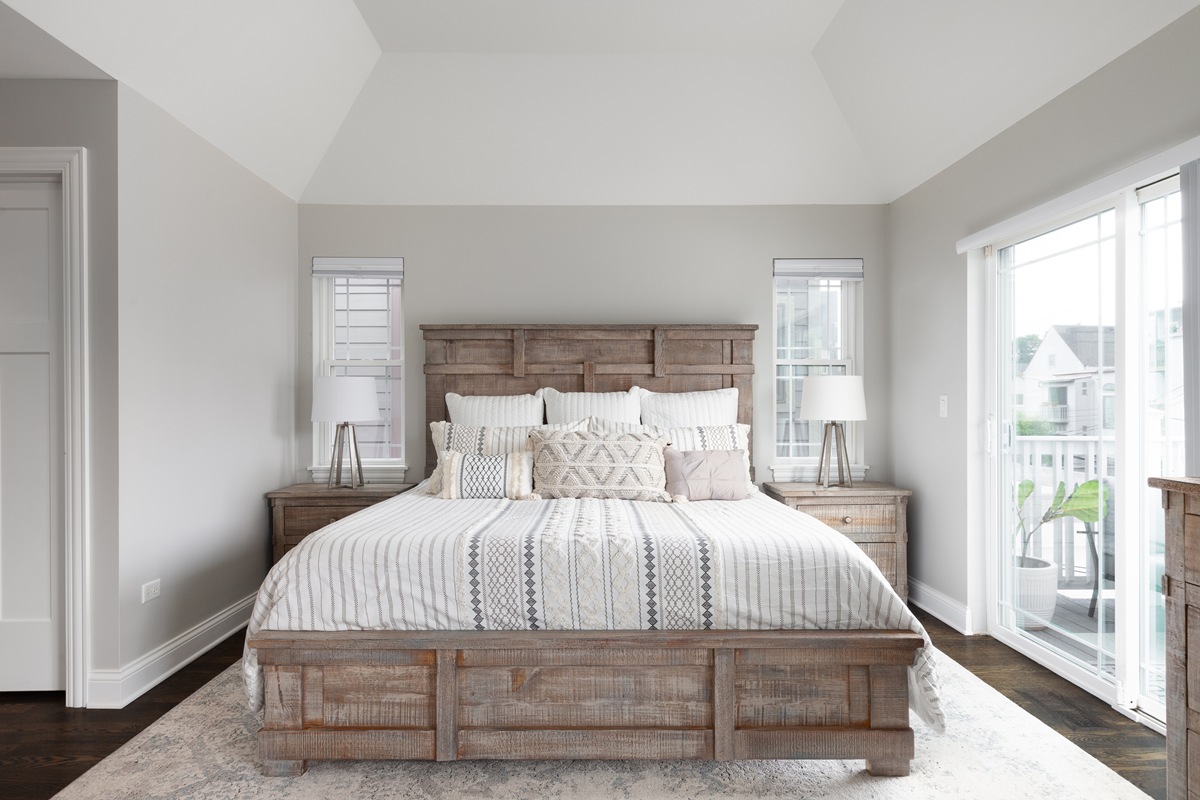 A bedroom with a wood headboard and footboard.