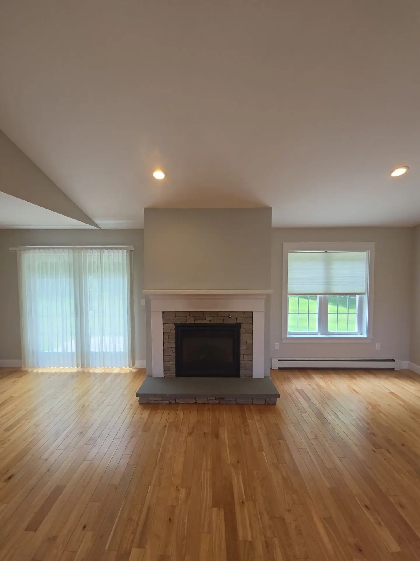 Fireplace Wall Interior Painting A newly painted residential living room wall featuring a stone fireplace and light gray paint.