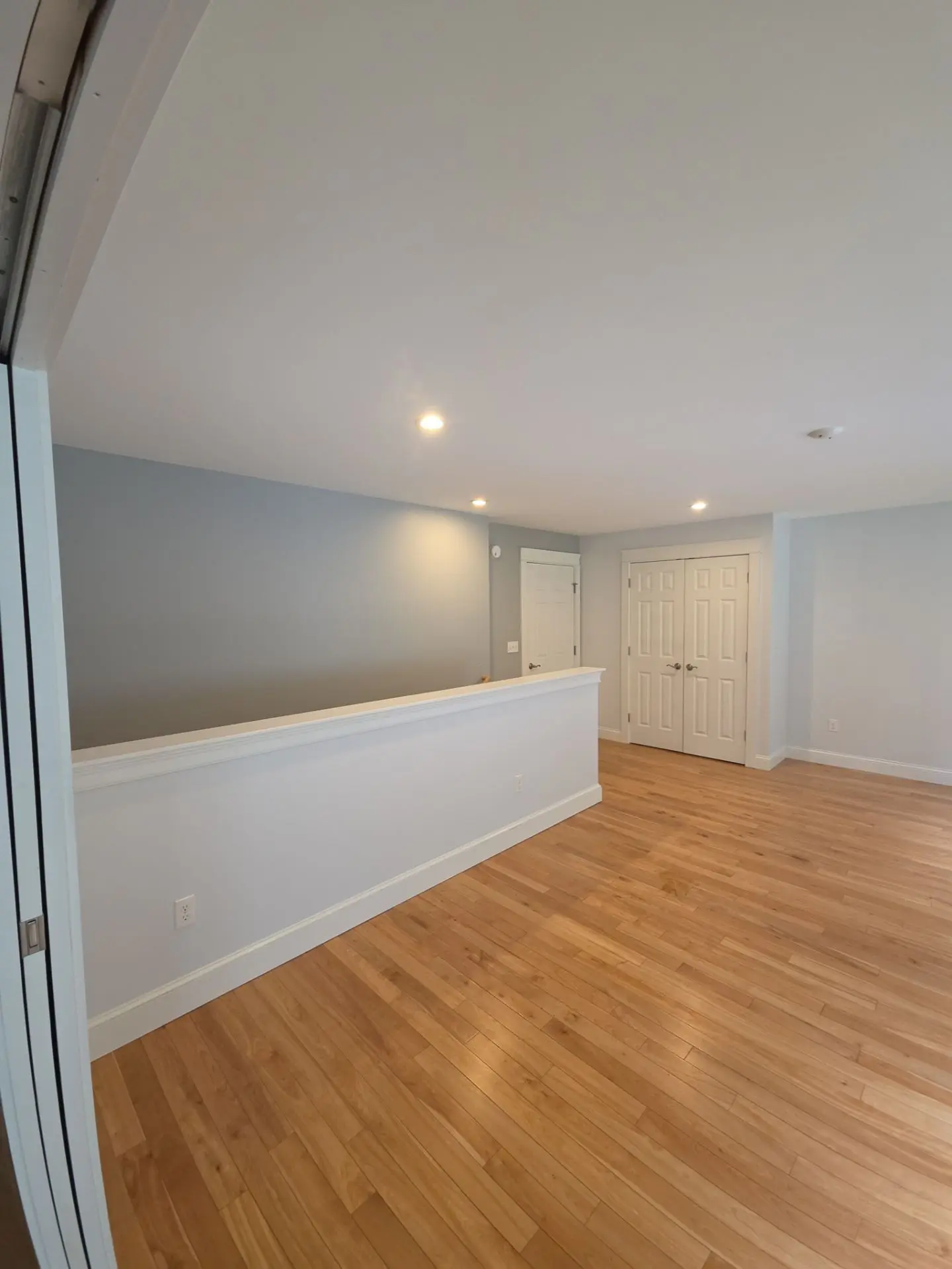 Modern Interior Painting in Residential Hallway A freshly painted residential hallway or loft area featuring light blue and white walls with hardwood flooring.